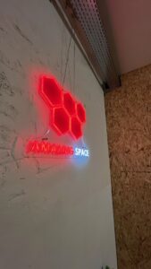 Neónové logo Amazing Space v spoločných priestoroch hudobnej skúšobne